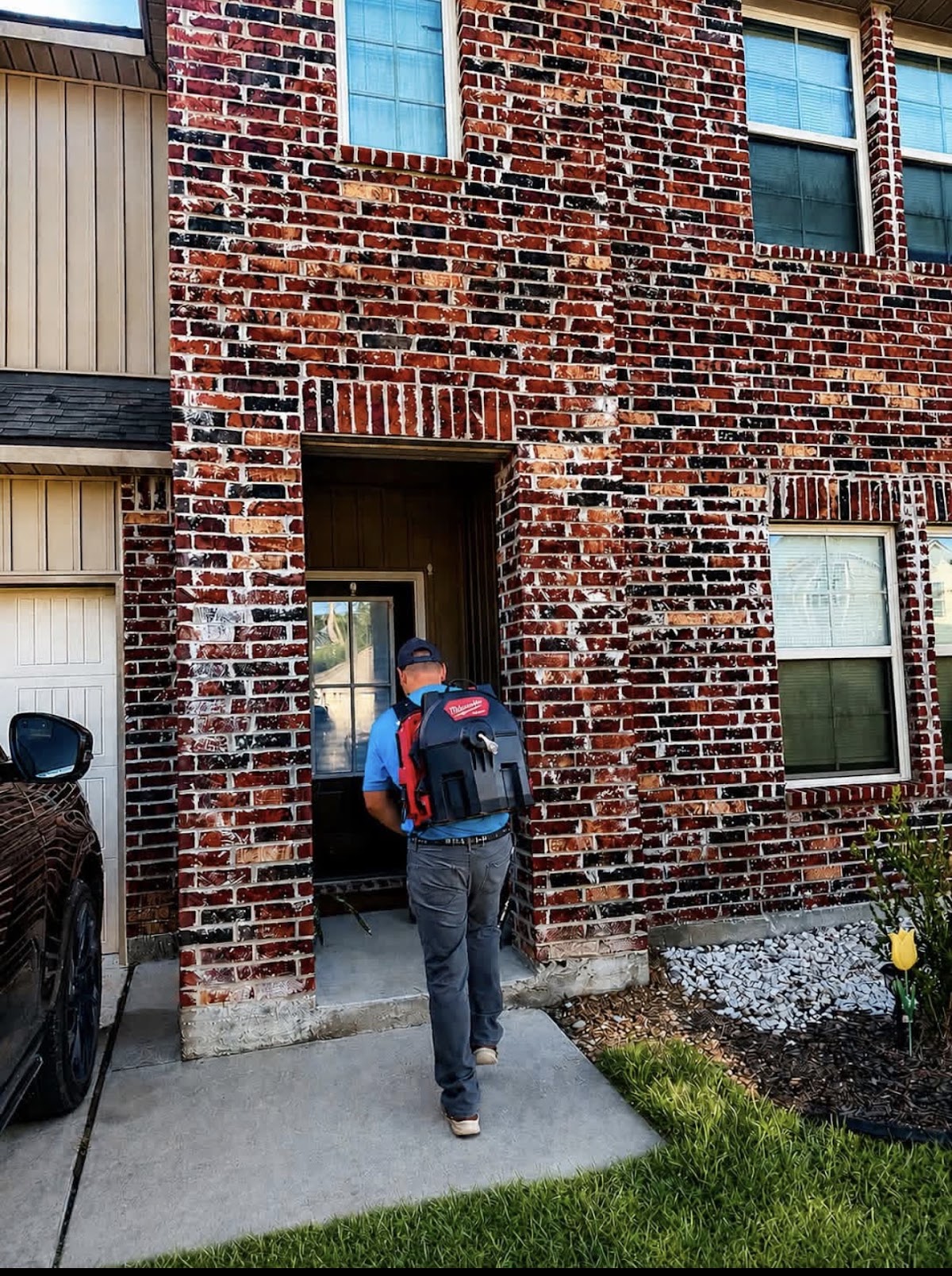 Simply Plumbing arriving at a brick home with tools in hand